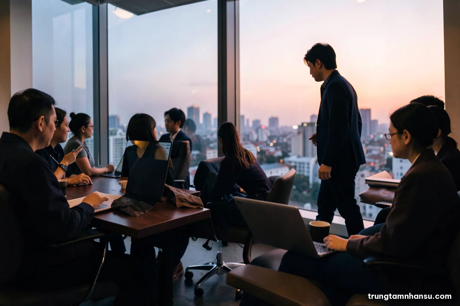 Low angle shot of an empty executive chair beside a large window overlooking a Vietnamese city skyline at dusk, a younger professional silhouette approaching, warm amber and deep navy palette