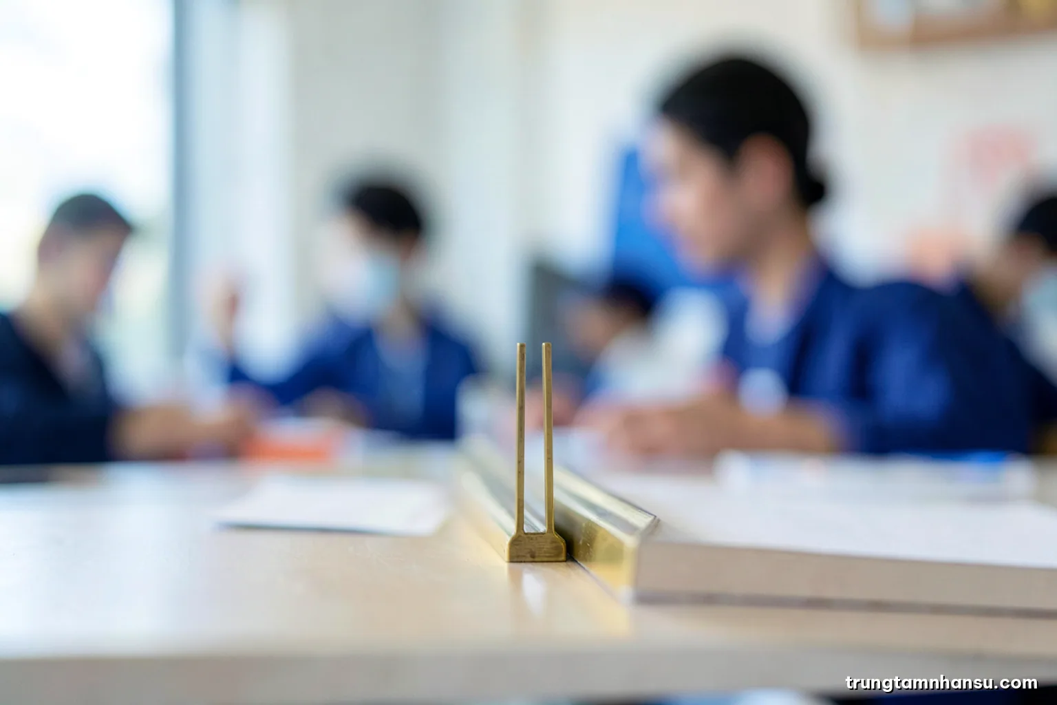 Macro shot of two parallel brass rails rising side by side on a laboratory shelf, shallow depth of field, a blurred researcher in the background, cool blue and gold palette